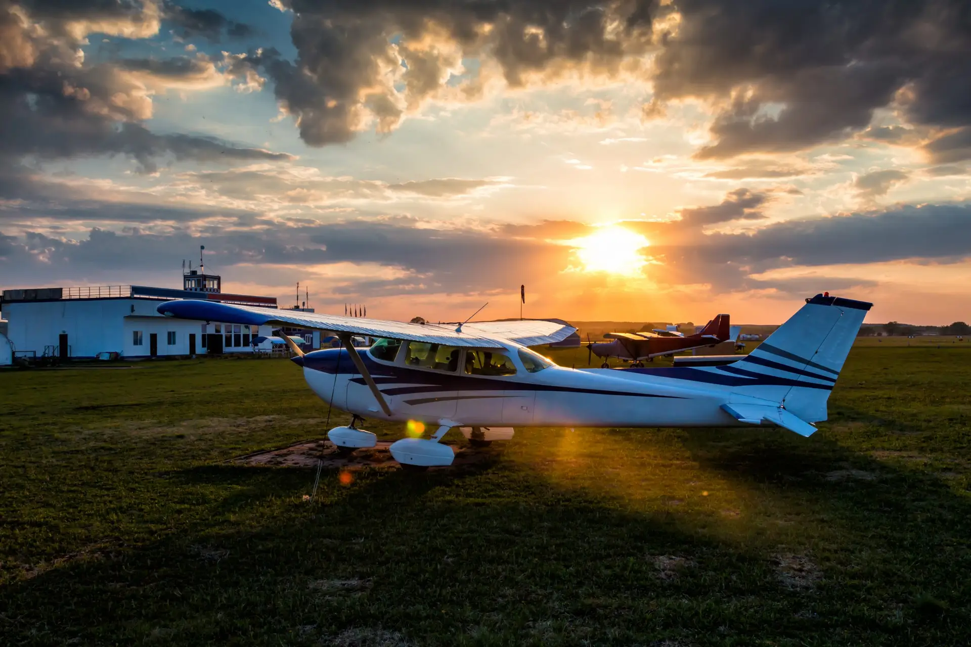 Small private airplanes on the airfield against the backdrop of a colorful sunset